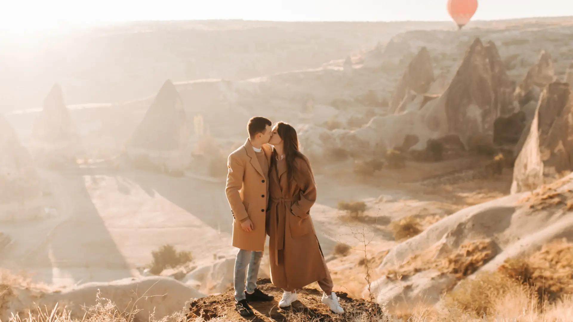 Couple kissing at a hot air balloon site