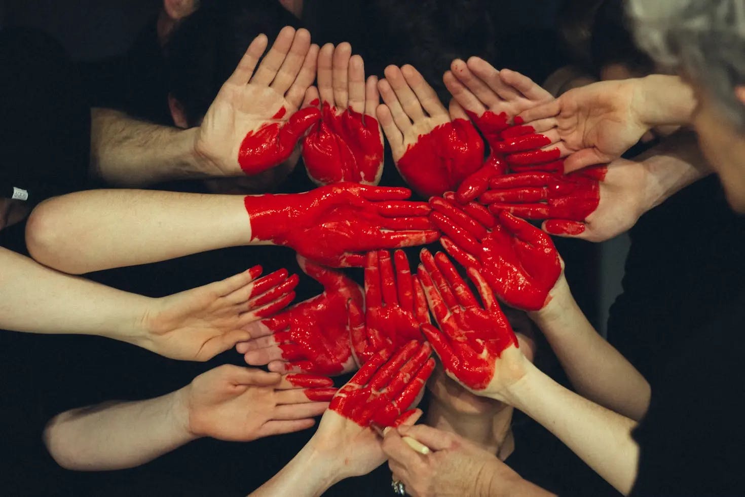 People making a heart shape with their painted hands