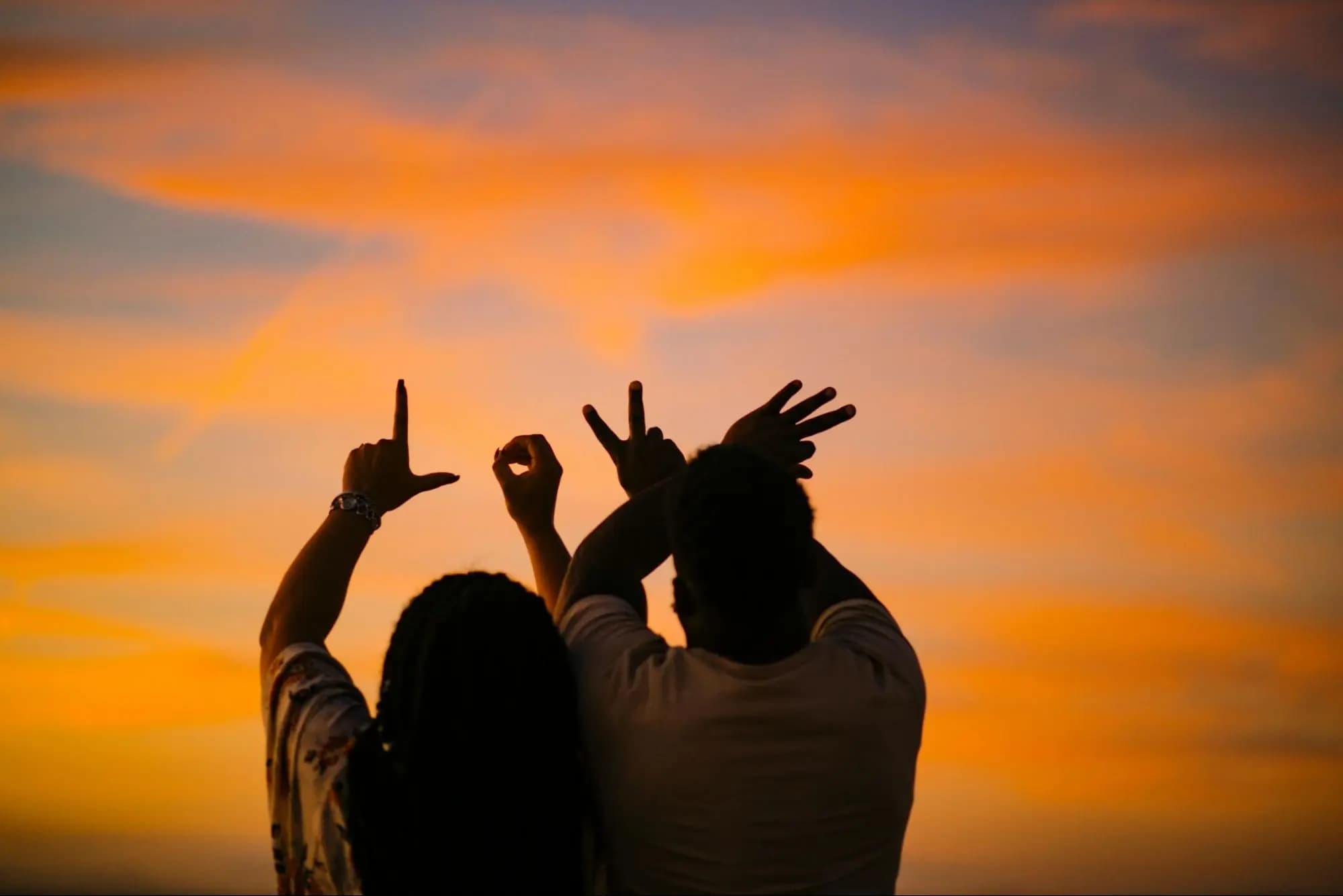 Couple forming the word 'LOVE' with their hands