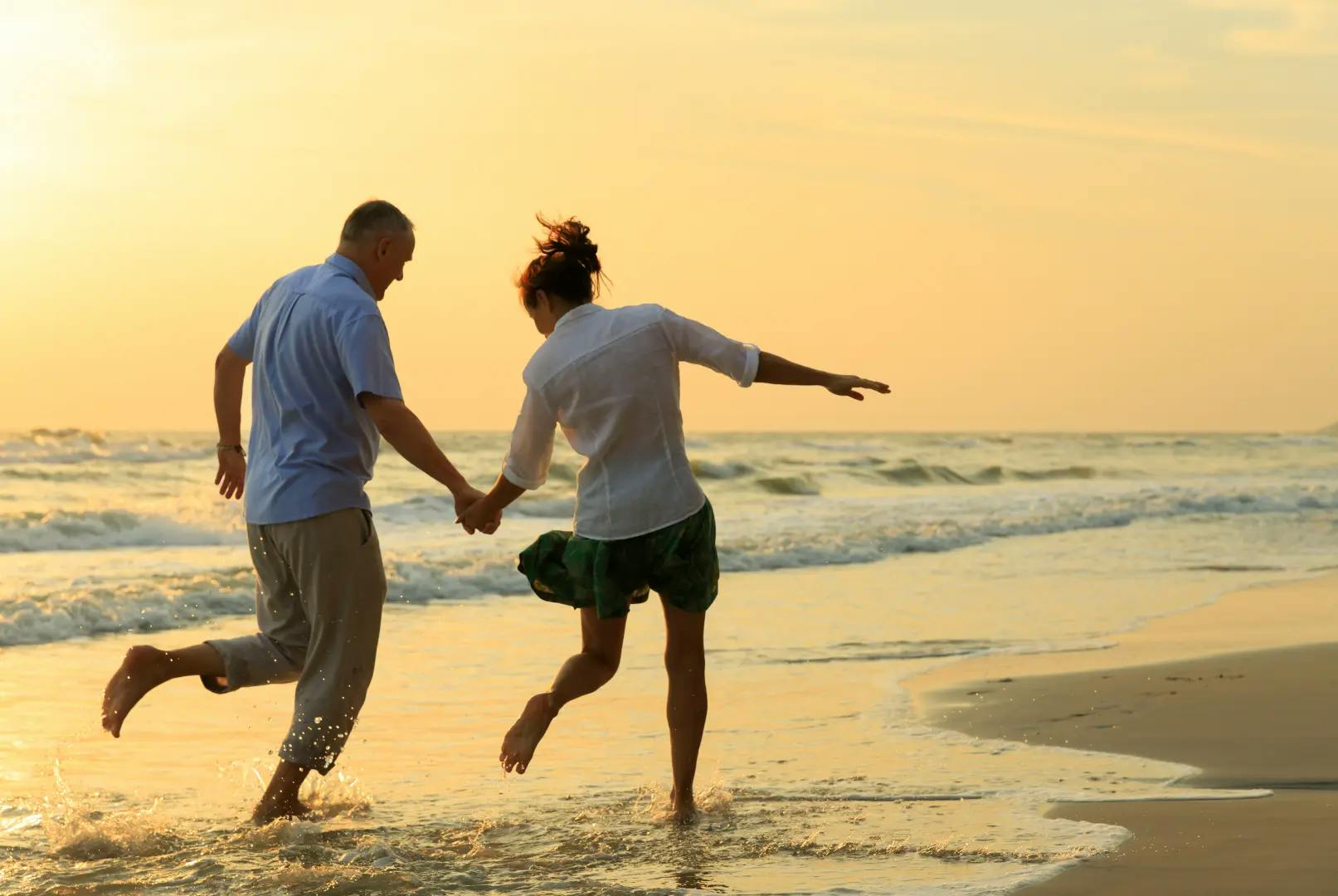 A couple running and having fun on the beach shore